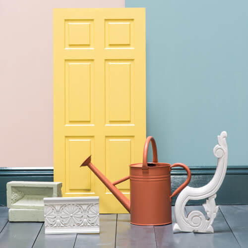 yellow door, watering can, blue wall and decorative stonework