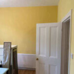 Newly painted lounge with main wall Farrow and Ball, Dayroom Yellow and feature wall painted Yellow Ground.