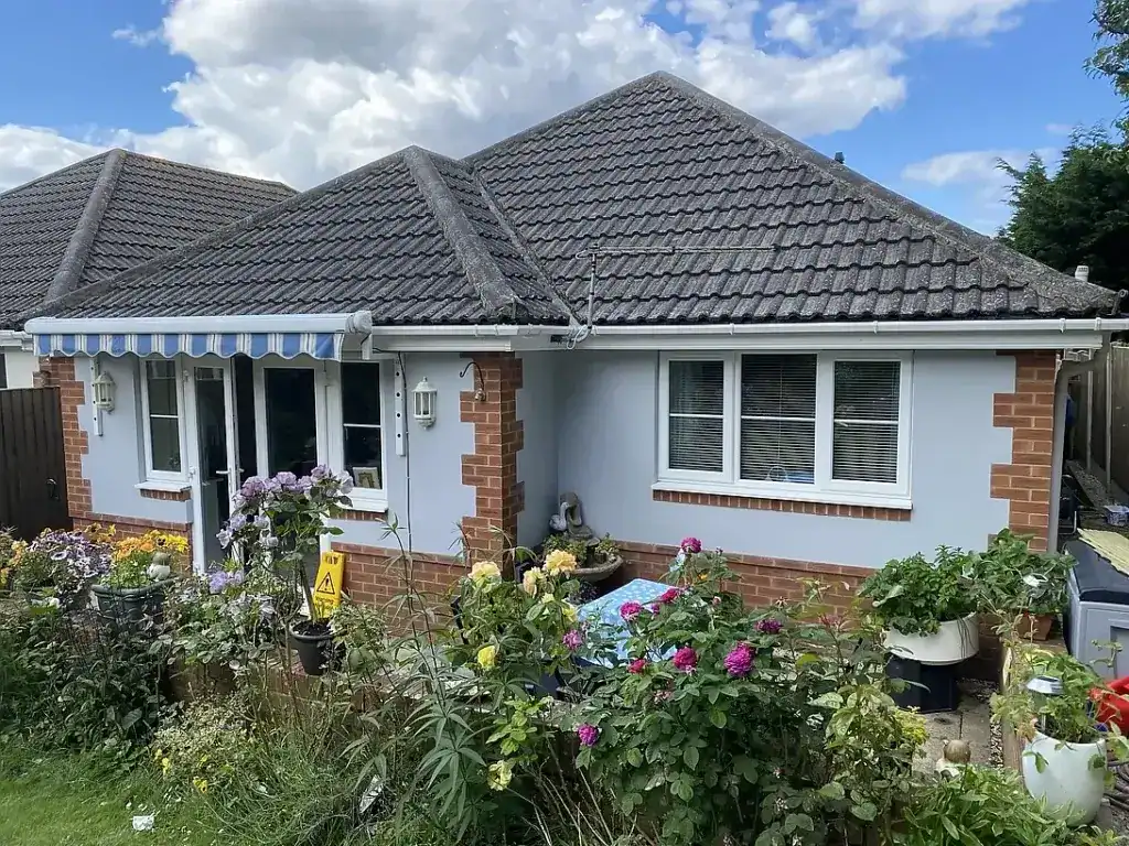 Modern UK bungalow with freshly painted blue-grey exterior walls, white trim, and landscaped garden.