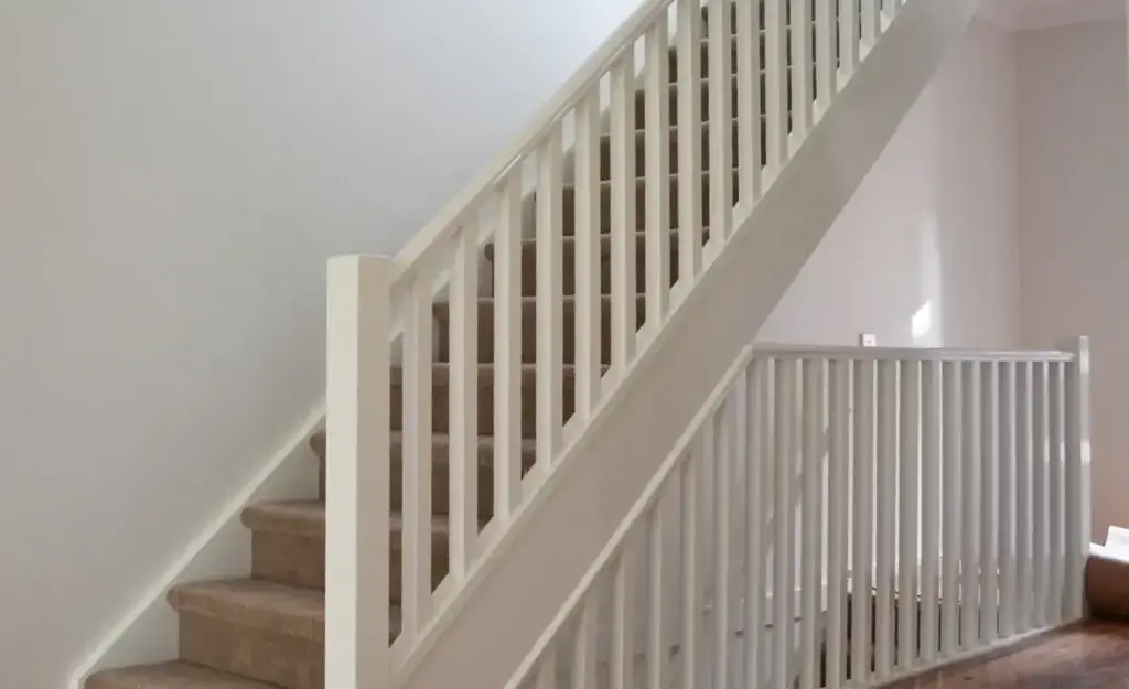 Elegant white staircase with a wall-mounted stringer, showcasing a modern design and clean lines.