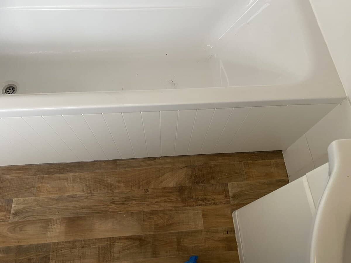 Bathroom renovation with fresh paint and wood flooring. Bath Panel Fitted.